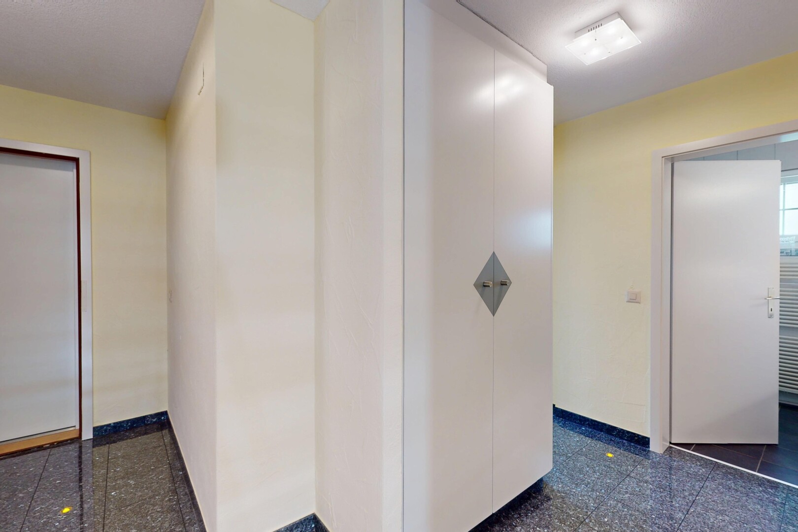 couloir avec granite finish floor, sol en finition granit, granite tile, drywall, et cloison sèche