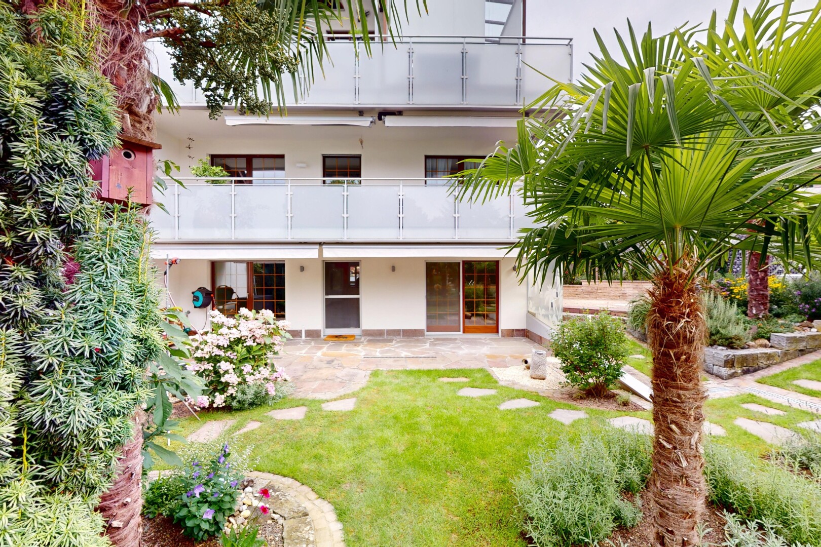 façade avec bardage en stuc, terrasse, balcon, property visible, et overcast