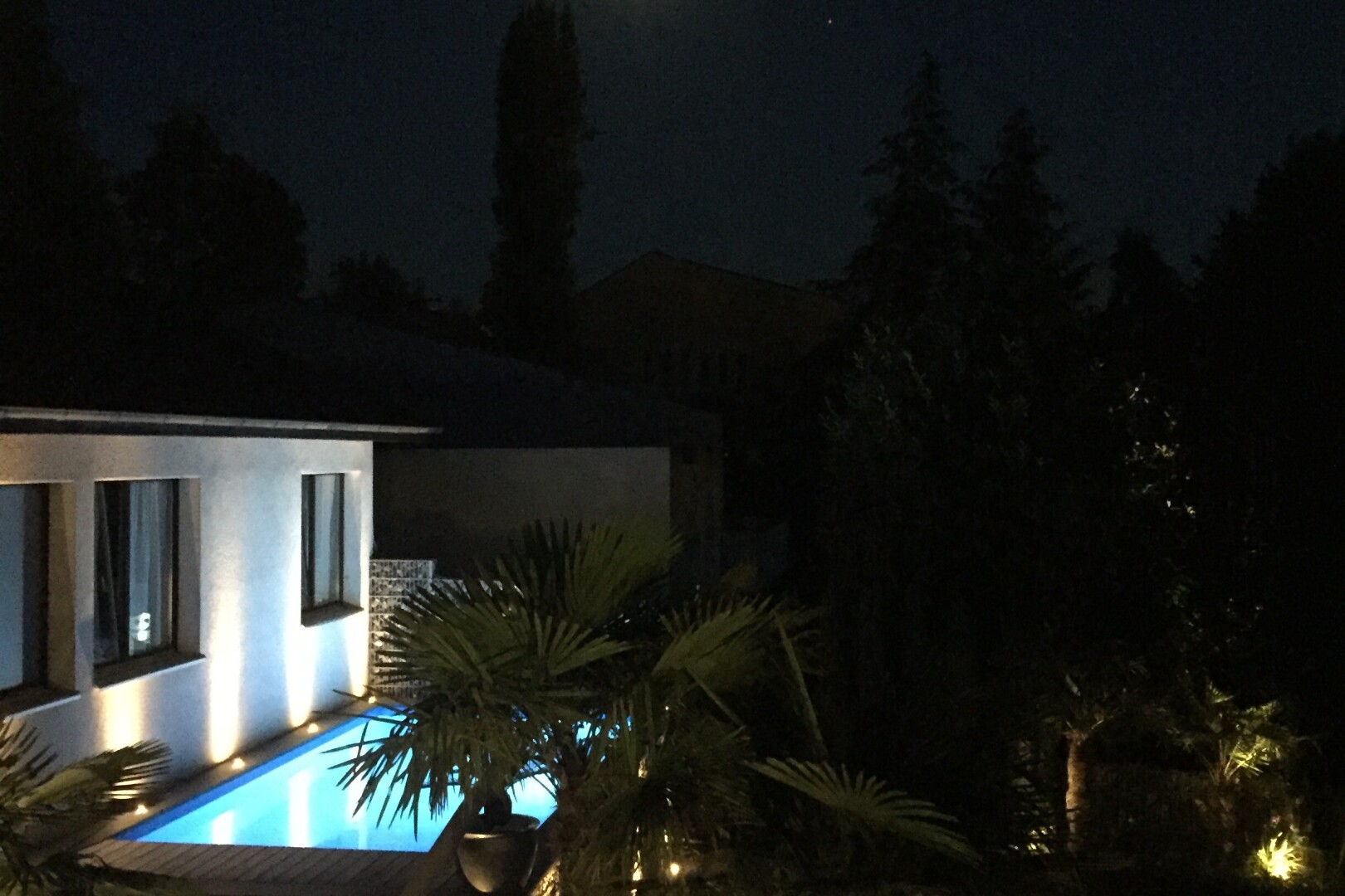 piscine avec night time, property visible, piscine, et télévision