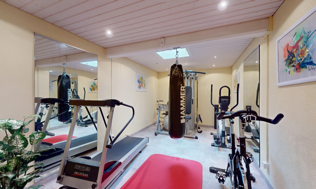 gym avec inside property, drywall, cloison sèche, beamed ceiling, et wood ceiling