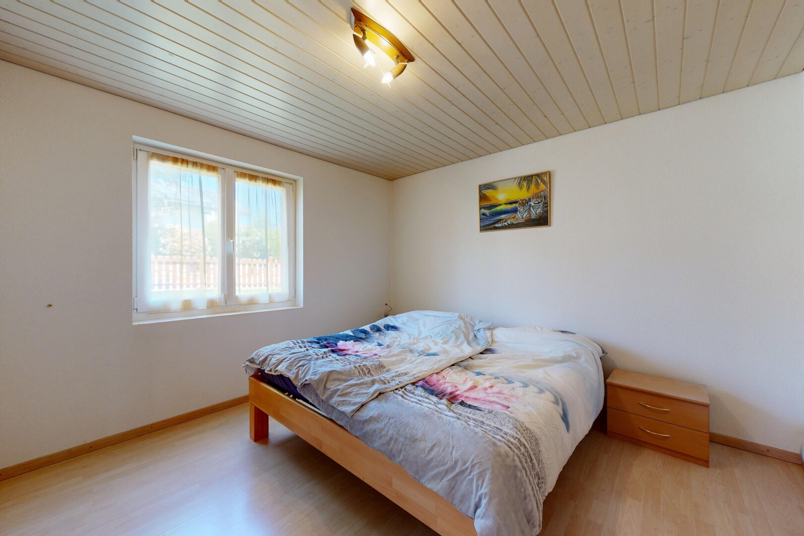 chambre avec sol en finition bois, wood finish floor, plafond en bois, wood ceiling, et lumière naturelle