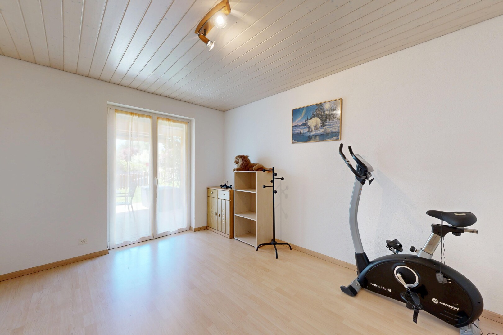 gym avec drywall, cloison sèche, natural light, lumière naturelle, et wood finish floor
