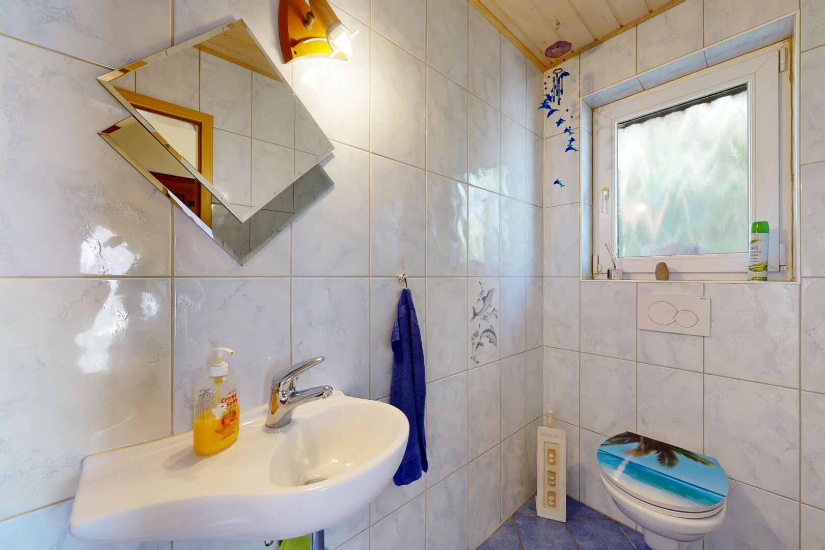 salle de bains avec natural light, lumière naturelle, tile wall, mur en carrelage, et toilette