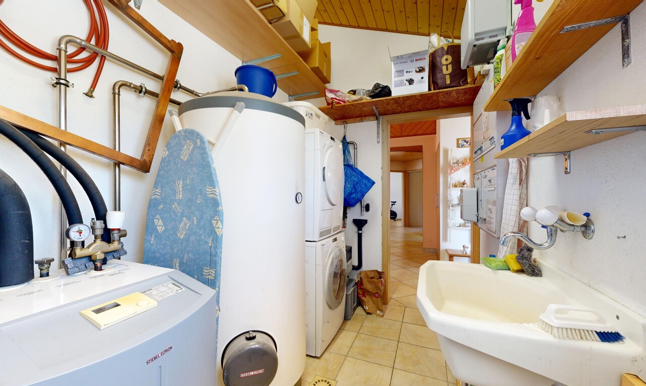 salle de bains avec inside property, évier, lave-linge et sèche-linge superposés, sol en carrelage, et tile floor