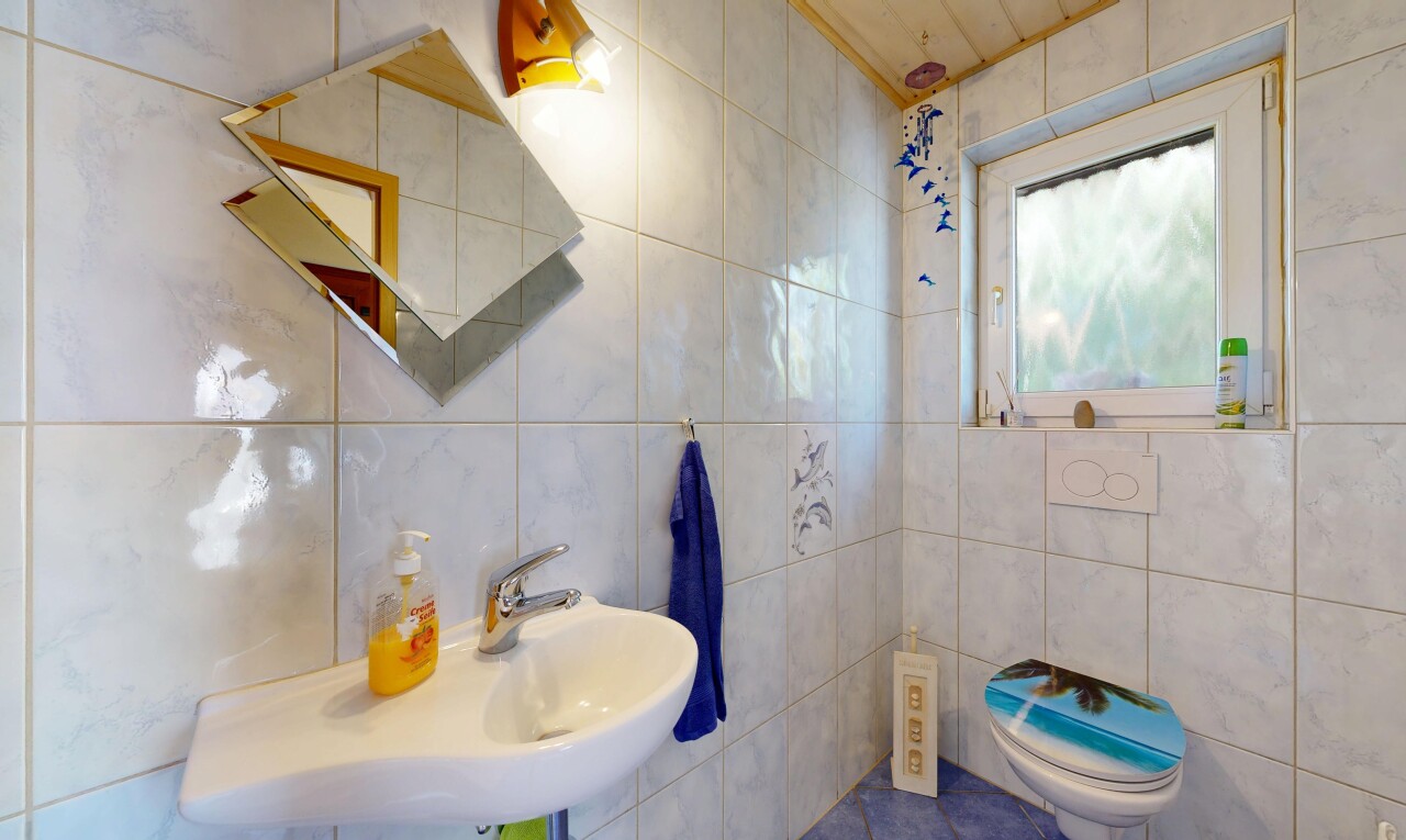 salle de bains avec natural light, lumière naturelle, tile wall, mur en carrelage, et toilette