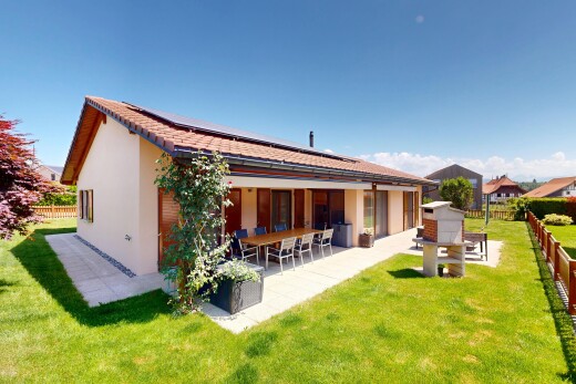 outdoor house with a patio area, stucco siding, and roof mounted solar panels