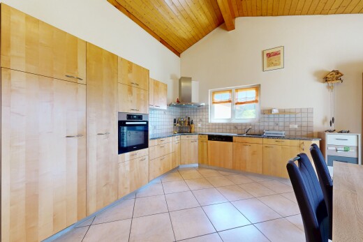 kitchen featuring light wood finish cabinets, dark countertops, oven, backsplash, and light tile patterned floors