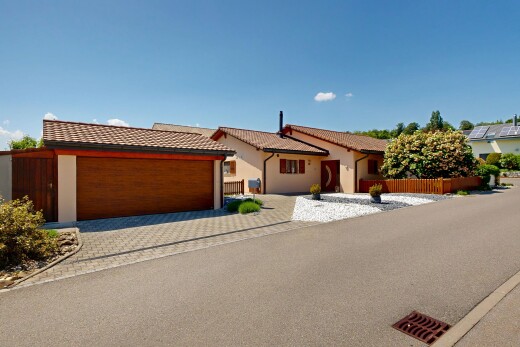 view of home with driveway, a tile roof, and stucco siding