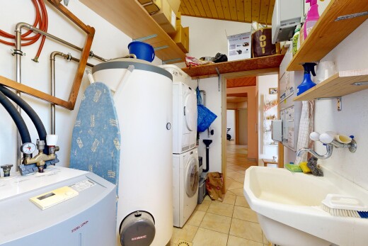 salle de bains avec inside property, évier, lave-linge et sèche-linge superposés, sol en carrelage, et tile floor