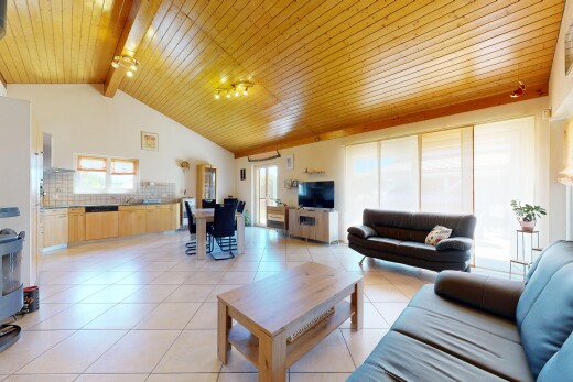 living room with a high wood beamed ceiling, plenty of natural light, and light tile patterned flooring