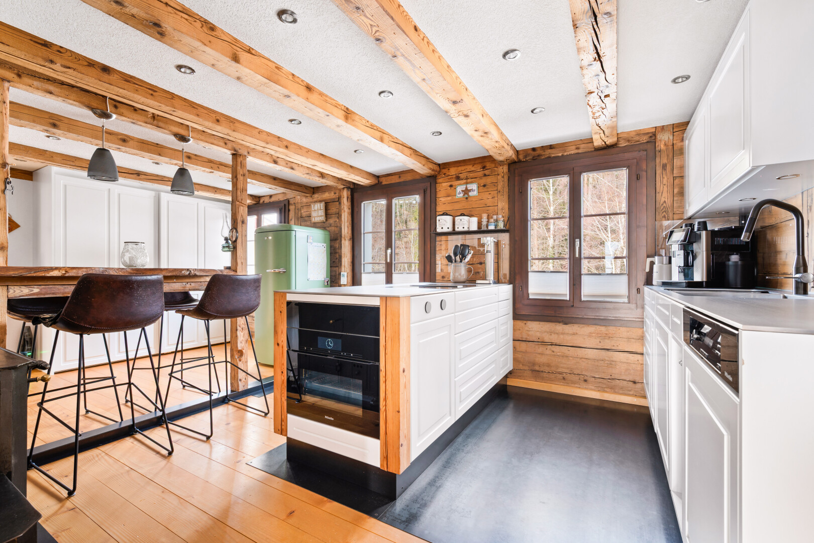 cuisine avec armoires blanches, white cabinets, plans de travail, light countertops, et sol en finition bois