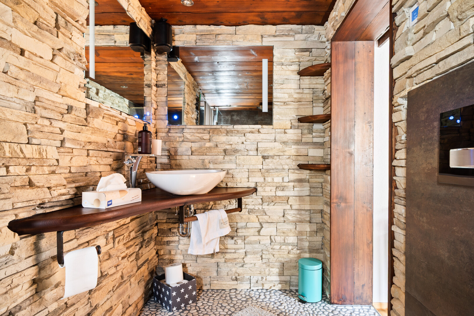 salle de bains avec mur en pierre, stone wall, miroir, inside property, et évier