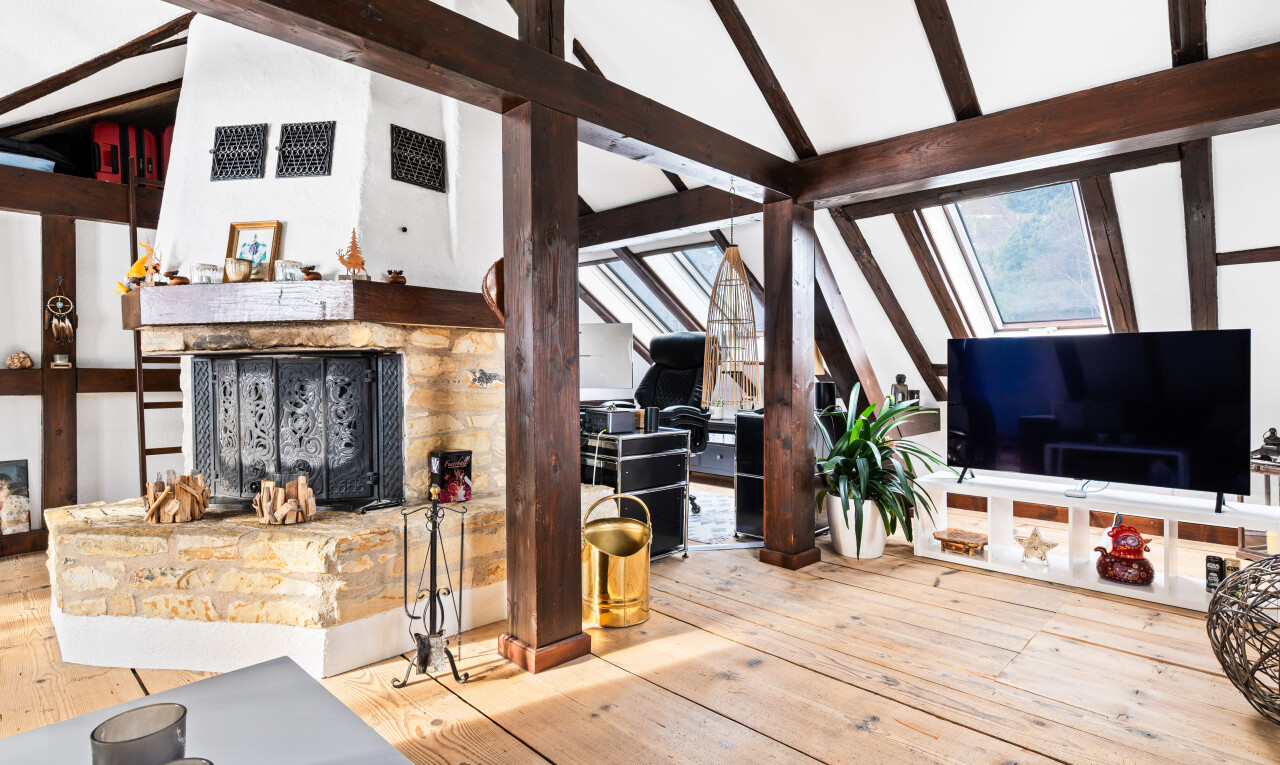salon avec cheminée, sol en finition bois, wood finish floor, plafond voûté, et vaulted ceiling