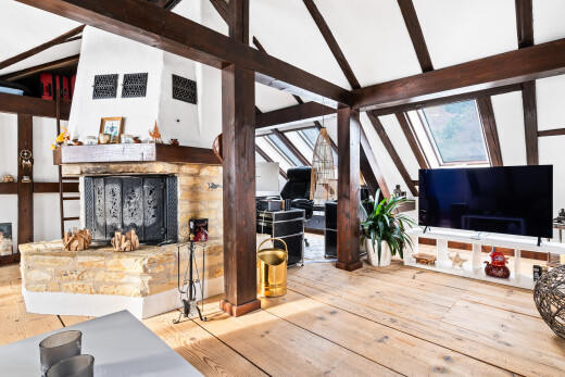 salon avec cheminée, sol en finition bois, wood finish floor, plafond voûté, et vaulted ceiling