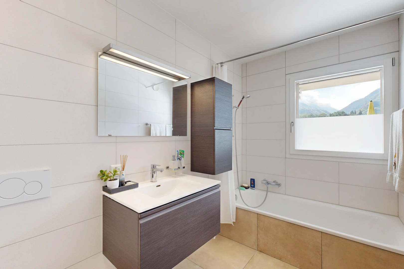 salle de bains avec lavabo (ou coiffeuse selon le contexte), douche-bain combinés, salle de bain complète, miroir, et évier