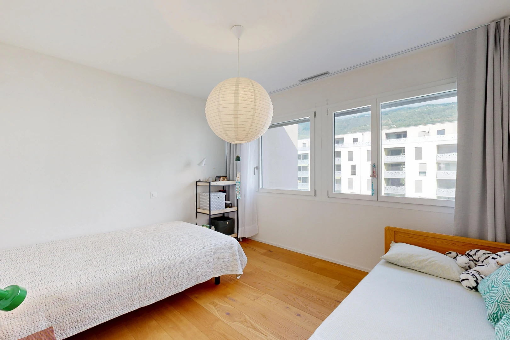 chambre avec éclairage suspendu, drywall, cloison sèche, wood finish floor, et sol en finition bois