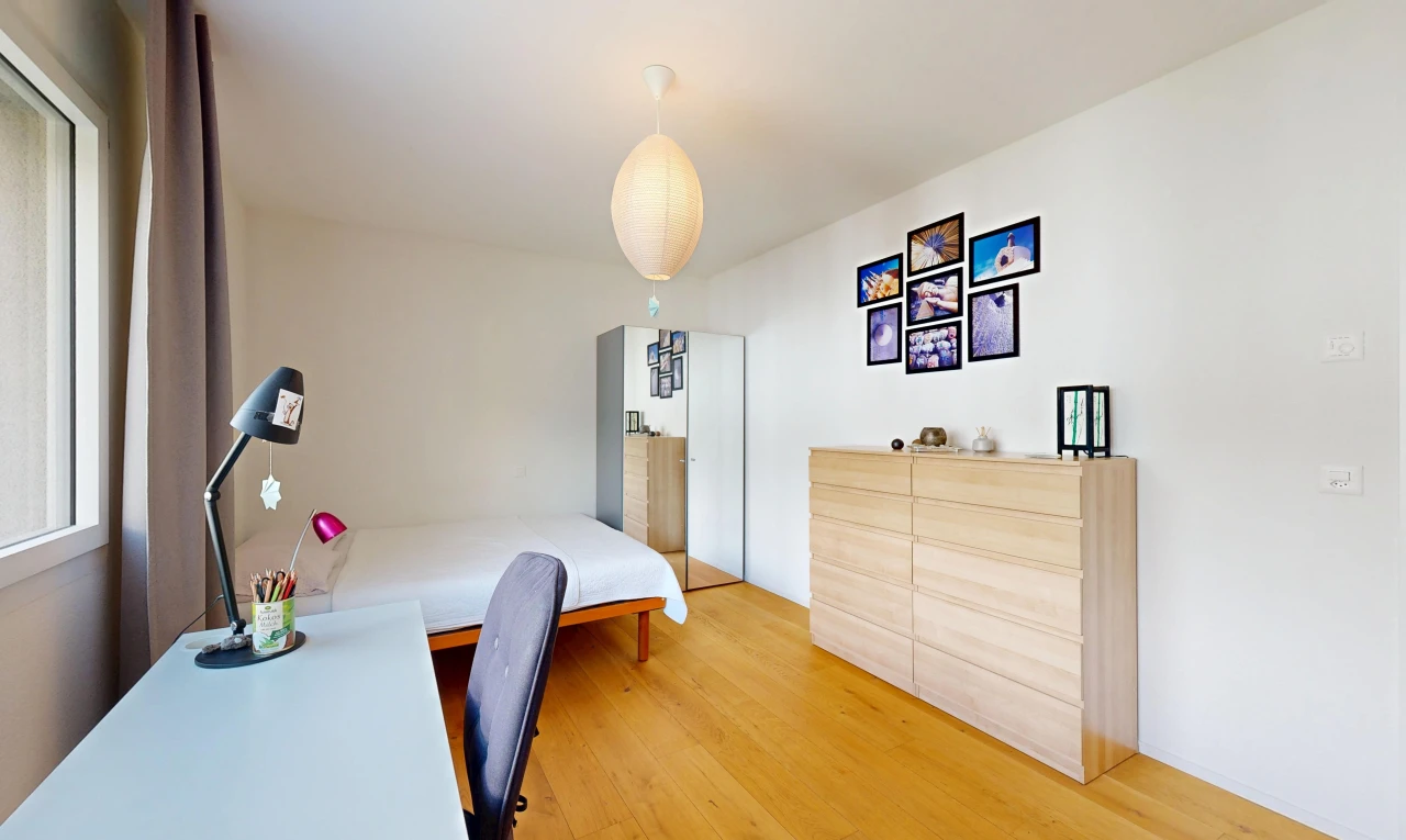 chambre avec cloison sèche, drywall, éclairage suspendu, sol en finition bois, et wood finish floor