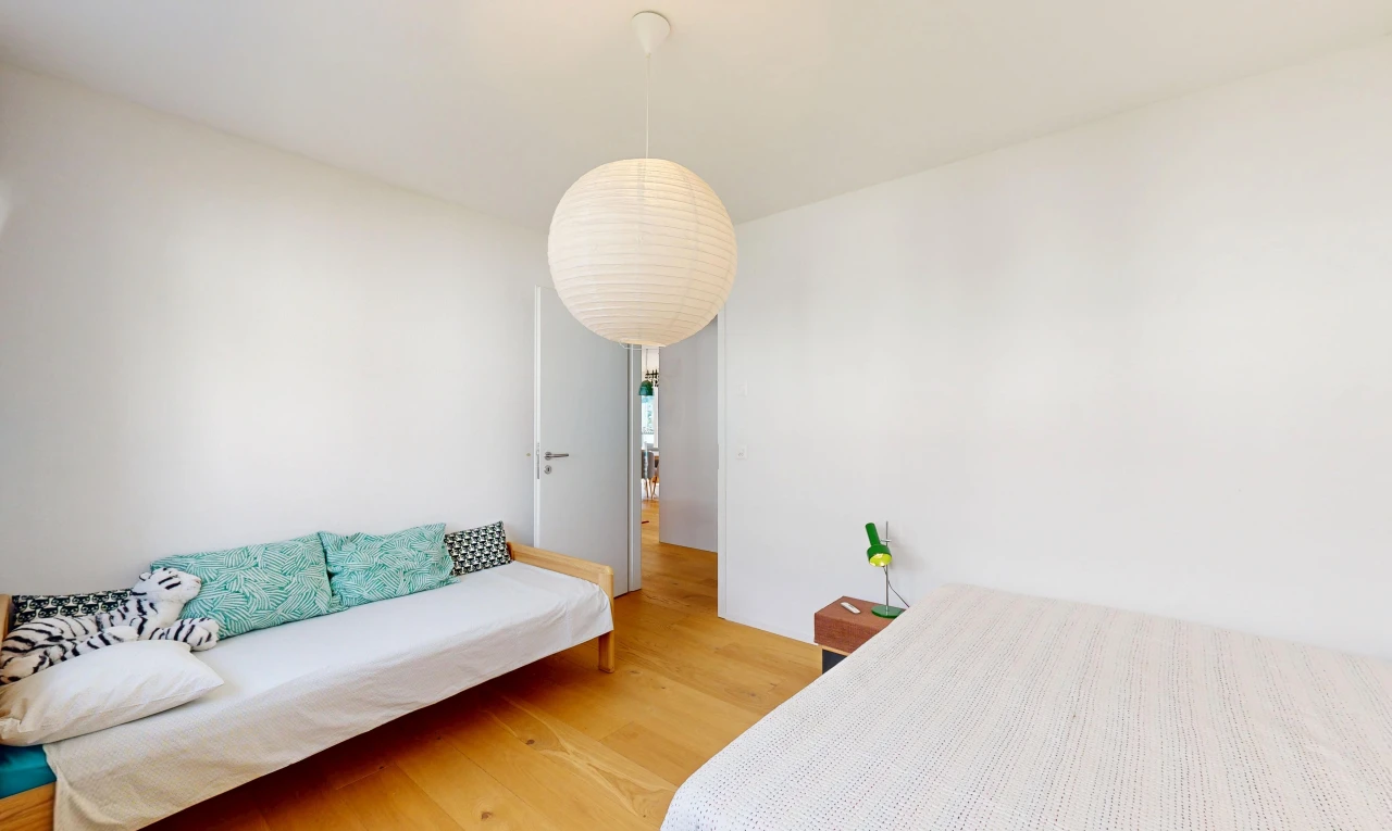 chambre avec drywall, cloison sèche, éclairage suspendu, wood finish floor, et sol en finition bois