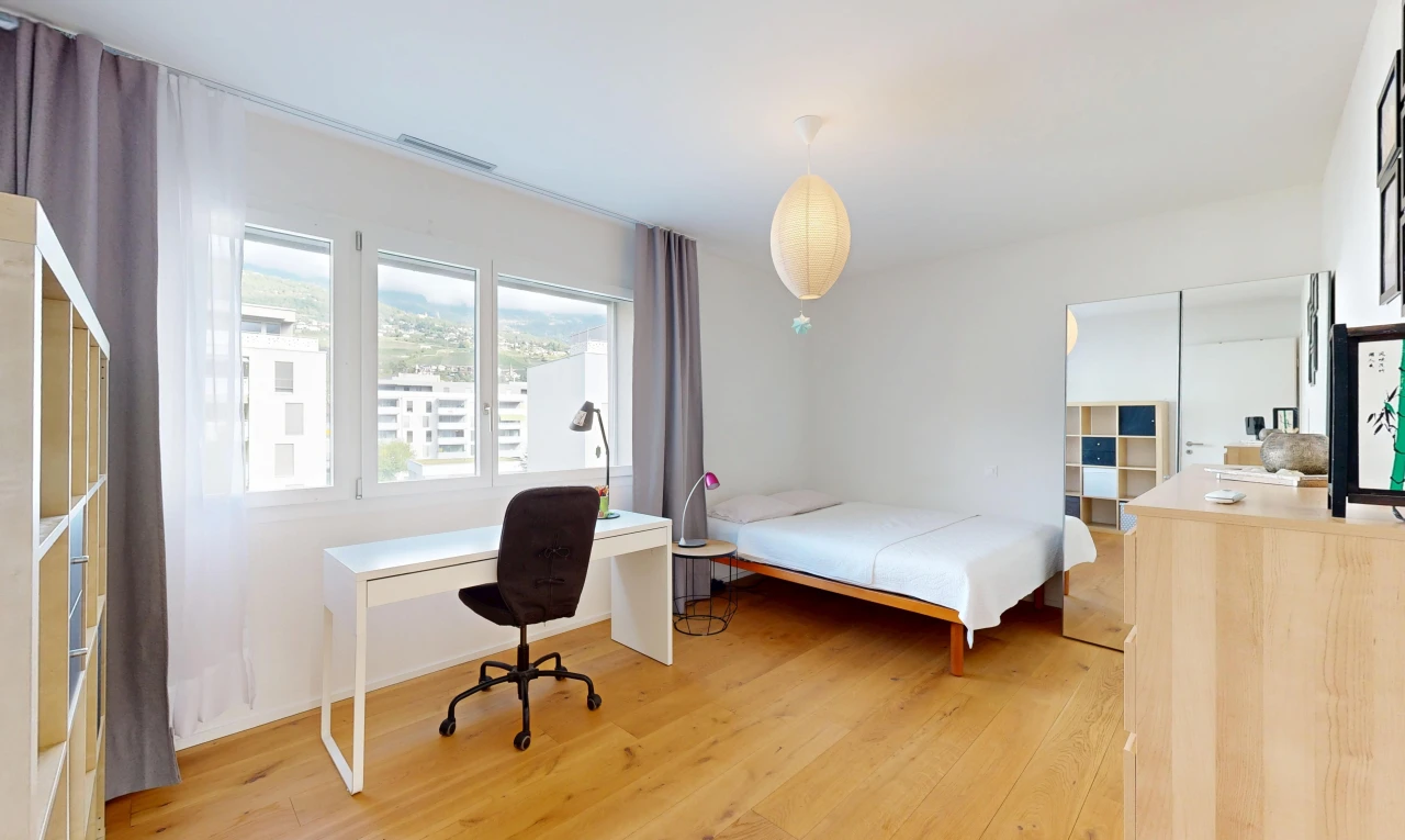 chambre avec espace bureau, sol en finition bois, wood finish floor, éclairage suspendu, et cloison sèche