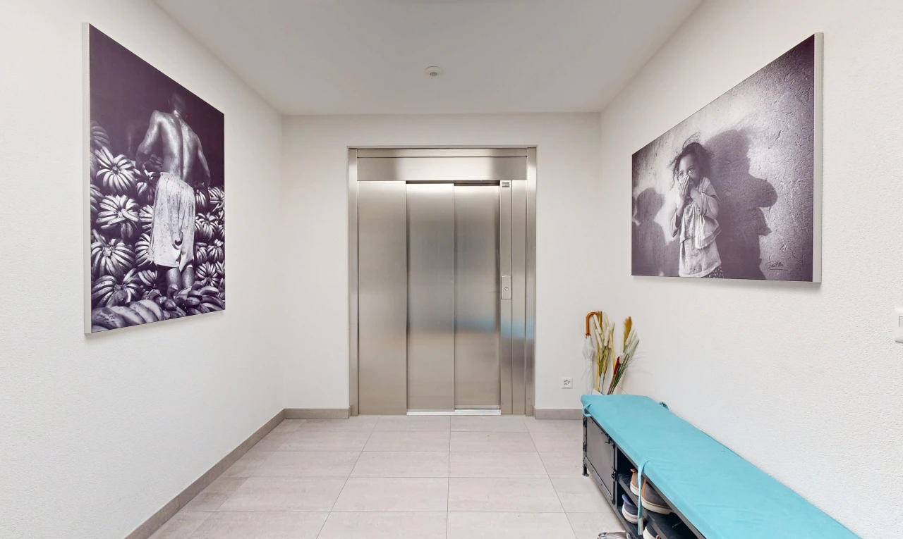 couloir avec ascenseur, light floor, inside community, plinthes murales, et baseboards wall