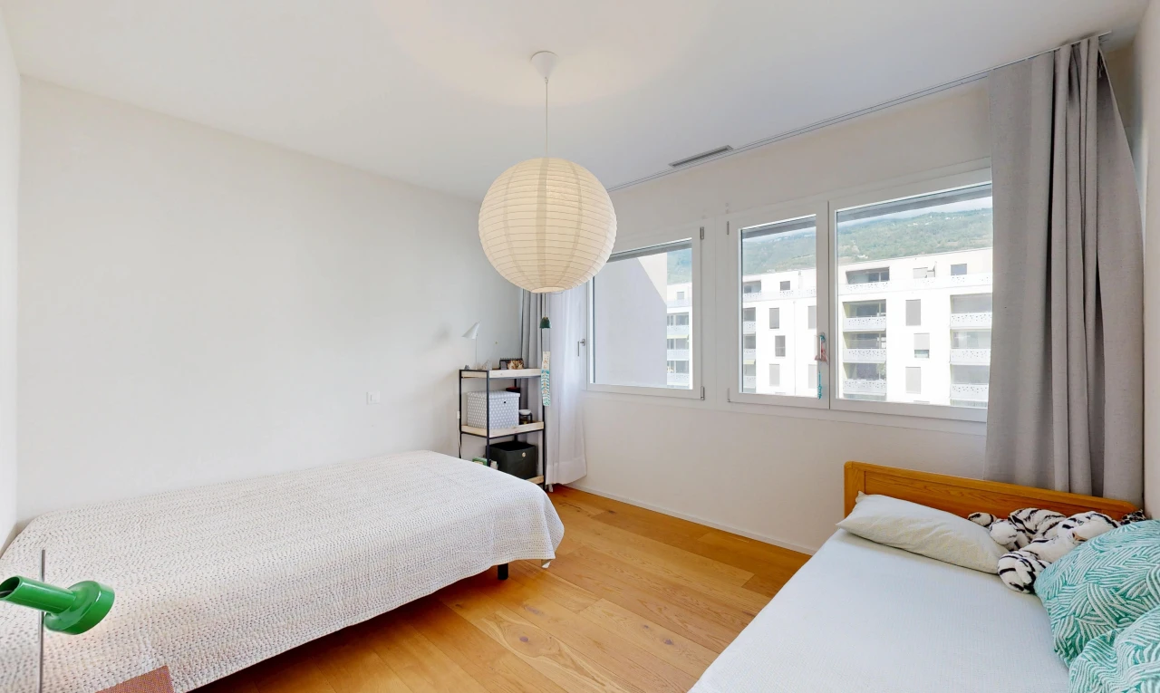 chambre avec éclairage suspendu, drywall, cloison sèche, wood finish floor, et sol en finition bois