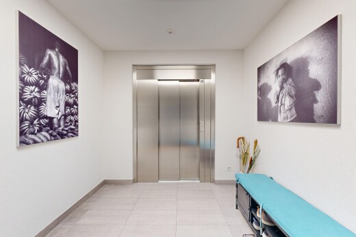 couloir avec ascenseur, light floor, inside community, plinthes murales, et baseboards wall