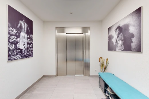 couloir avec ascenseur, light floor, inside community, plinthes murales, et baseboards wall