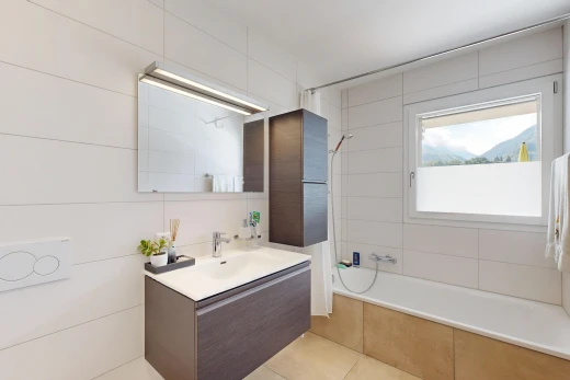 salle de bains avec lavabo (ou coiffeuse selon le contexte), douche-bain combinés, salle de bain complète, miroir, et évier