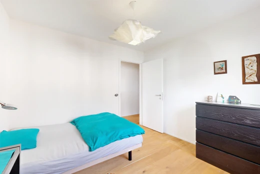 chambre avec drywall, cloison sèche, éclairage suspendu, wood finish floor, et sol en finition bois