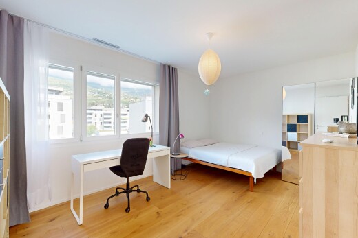 chambre avec espace bureau, sol en finition bois, wood finish floor, éclairage suspendu, et cloison sèche