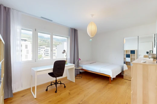 chambre avec espace bureau, sol en finition bois, wood finish floor, éclairage suspendu, et cloison sèche