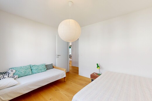 chambre avec drywall, cloison sèche, éclairage suspendu, wood finish floor, et sol en finition bois