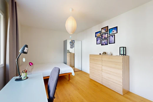 chambre avec cloison sèche, drywall, éclairage suspendu, sol en finition bois, et wood finish floor