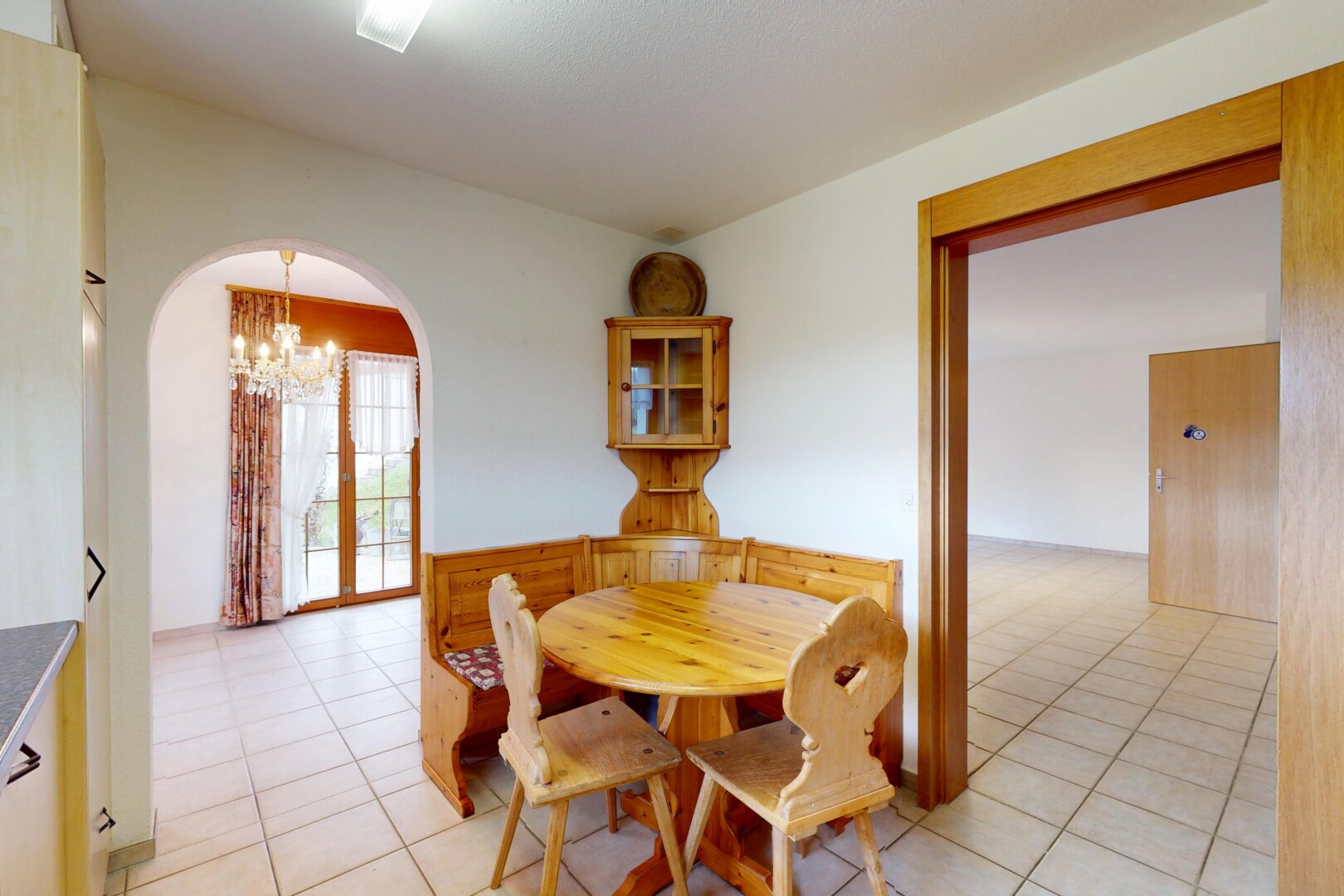 esszimmer mit bemerkenswerter kronleuchter, gipskartonwand, fliesenboden, natürliches licht, und gewölbte gehwege