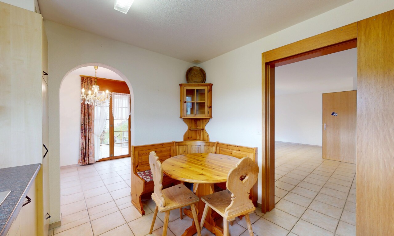 esszimmer mit bemerkenswerter kronleuchter, gipskartonwand, fliesenboden, natürliches licht, und gewölbte gehwege