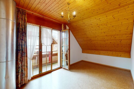 leerer raum mit gipskartonwand, dachschräge, natürliches licht, holzdecke, und bemerkenswerter kronleuchter