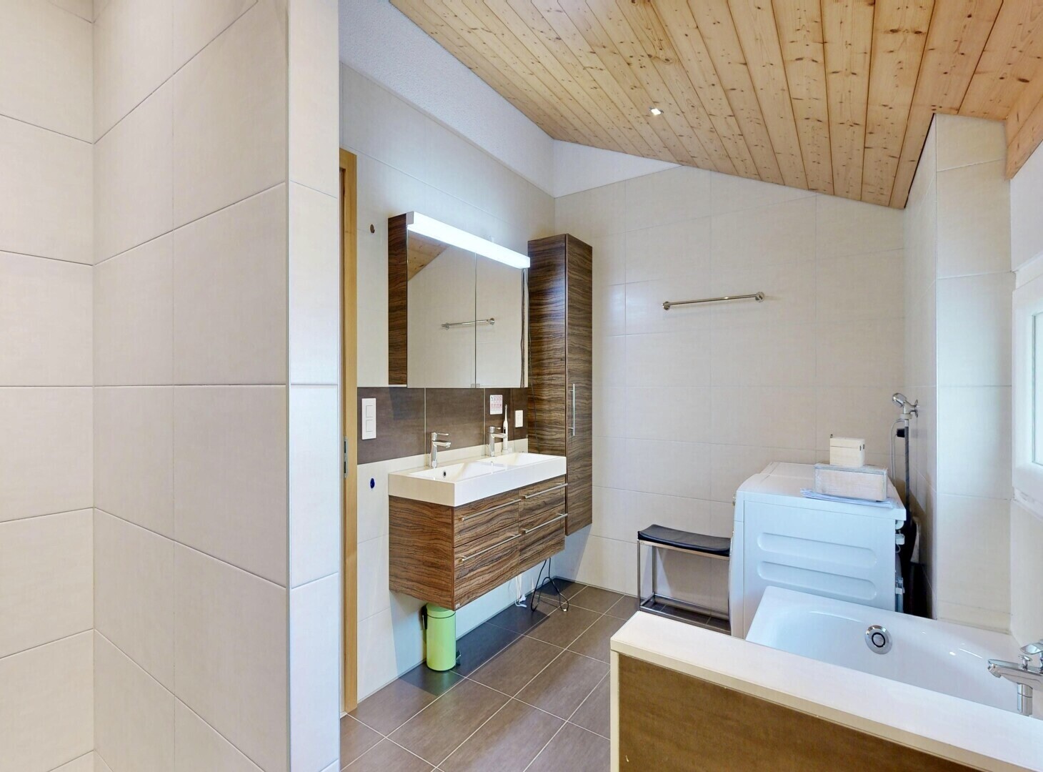 salle de bains avec tile wall, mur en carrelage, miroir, vaulted ceiling, et plafond voûté