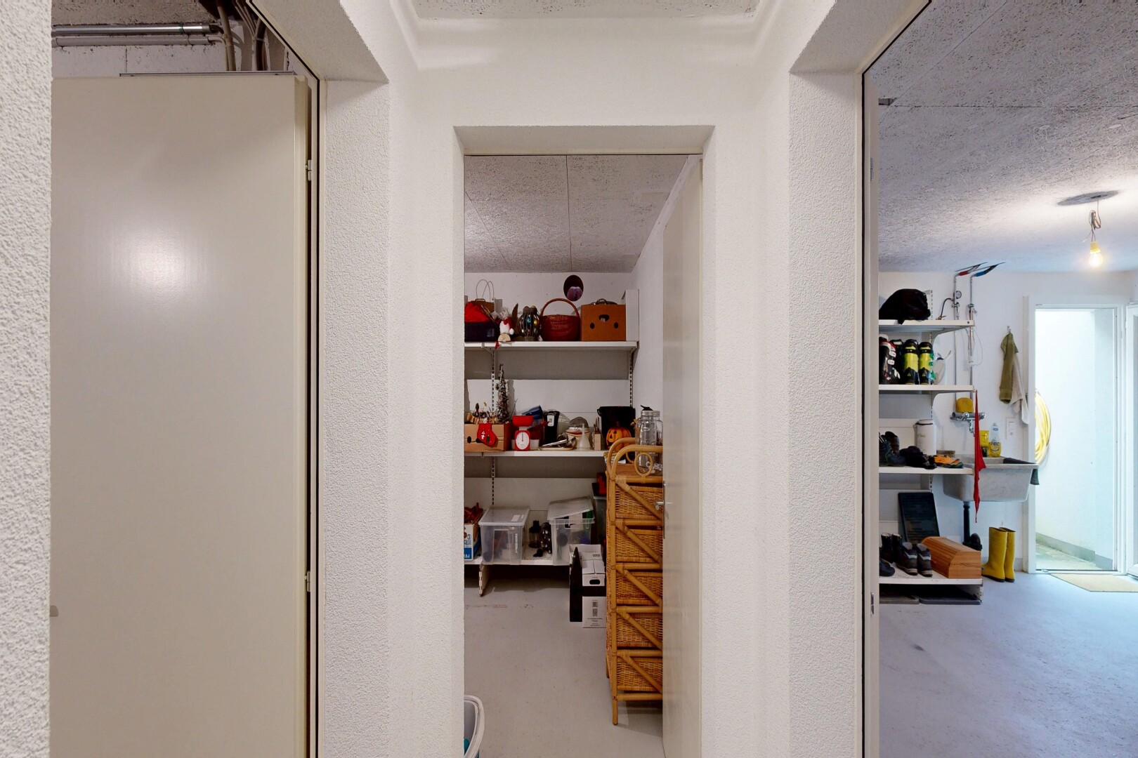 hall featuring concrete floors, a textured wall, and a textured ceiling