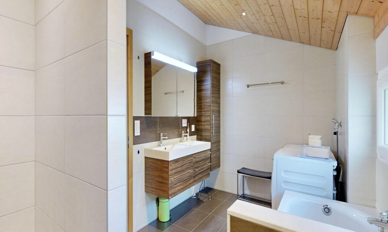 salle de bains avec tile wall, mur en carrelage, miroir, vaulted ceiling, et plafond voûté