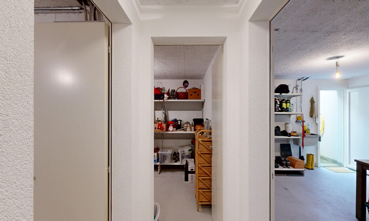hall featuring concrete floors, a textured wall, and a textured ceiling
