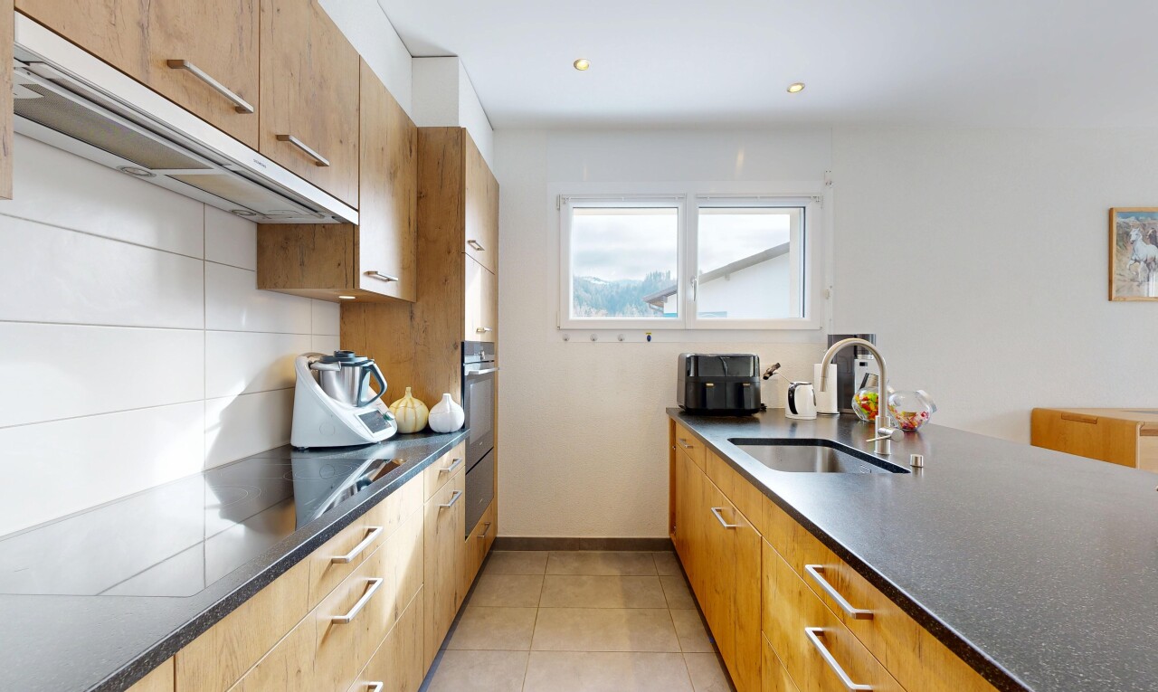 kitchen featuring dark stone counters, recessed lighting, wood finish cabinets, and light tile patterned flooring