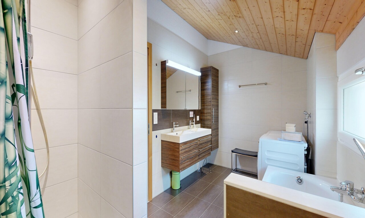 full bath with tile walls, vanity, a bath, dark tile patterned floors, and a vaulted wood ceiling