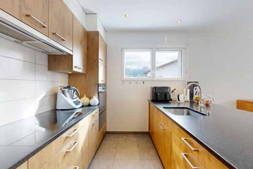 kitchen featuring dark stone counters, recessed lighting, wood finish cabinets, and light tile patterned flooring