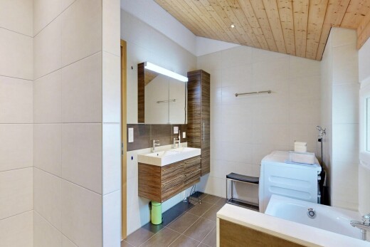 salle de bains avec tile wall, mur en carrelage, miroir, vaulted ceiling, et plafond voûté