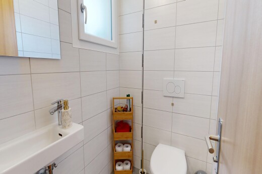 salle de bains avec miroir, toilette, inside property, évier, et mur en carrelage