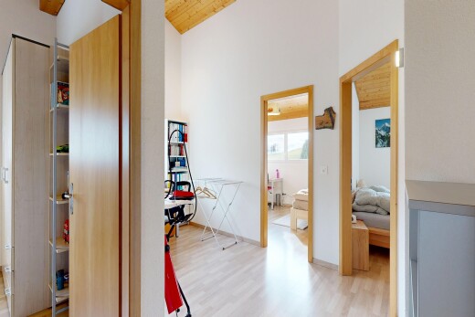 couloir avec inside property, cloison sèche, drywall, sol en finition bois, et wood finish floor