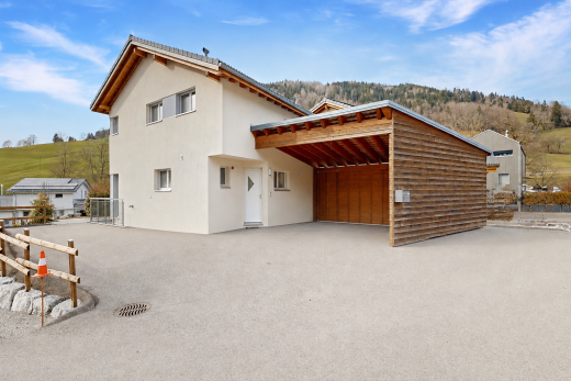 außenansicht mit stuckverkleidung, day time, property visible, und carport angeschlossen