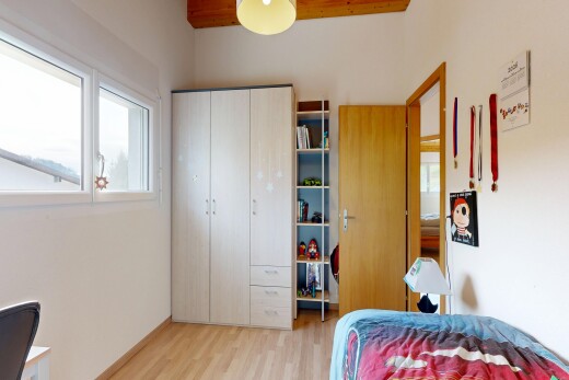 room / bedroom with light wood-style flooring, a closet, and a desk