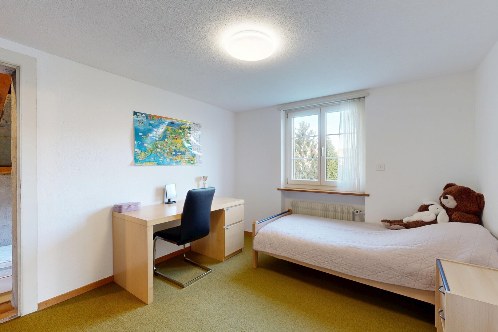 room / bedroom featuring light colored carpet, radiator, a textured ceiling, and a desk