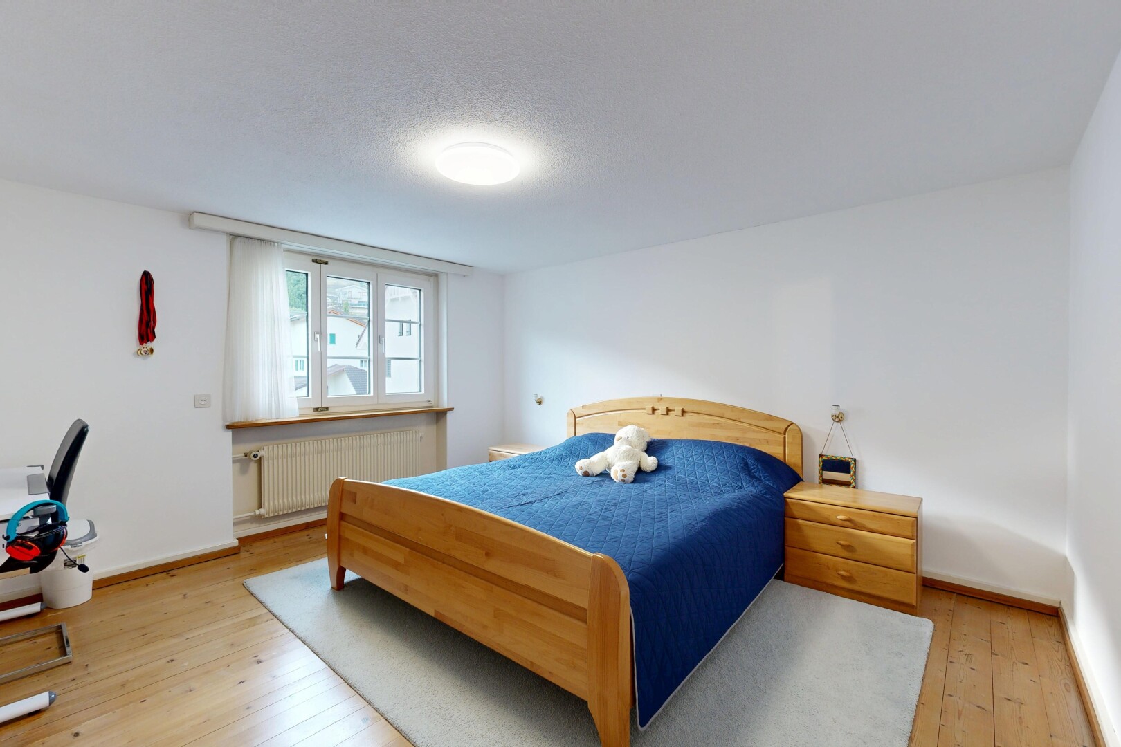 room with radiator, light wood-style flooring, and a textured ceiling